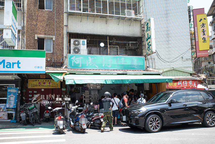 關渡超人氣小吃店，招牌模糊到看不清，店前黑壓壓人潮是指標，一字排開的滷味必點