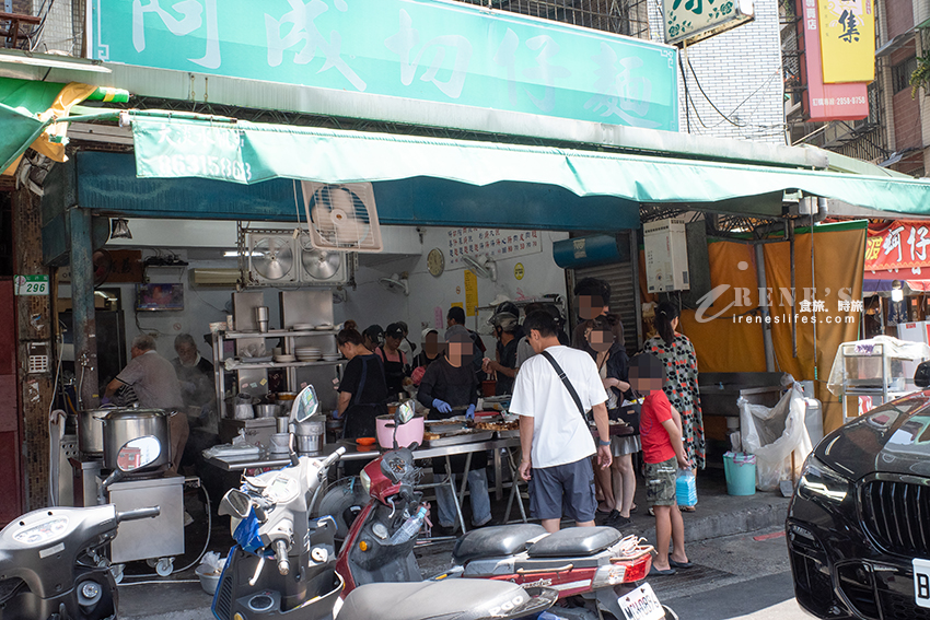 關渡超人氣小吃店，招牌模糊到看不清，店前黑壓壓人潮是指標，一字排開的滷味必點